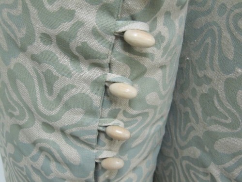 Wooden beaded trim sewn into the seam. fabric loops made as closures. 