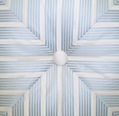 Mitred stripe forming a cross with silk covered button. 