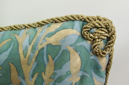 Hand applied rope/cord with a  double loop on the corner of the pillow face.  