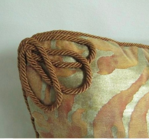 Hand applied rope/cord with a  triple loop on the corner of the pillow face.
